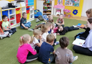 Dzieci słuchają bajki czytanej przez licealistki